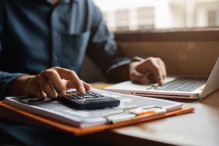 Foto: Person tippt auf Laptop